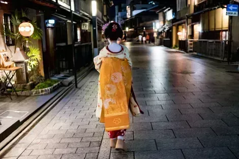 A geisha walking at night in Gion - Kyoto