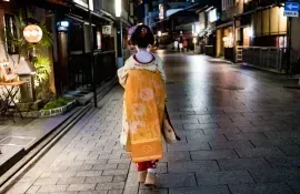 A geisha walking at night in Gion - Kyoto