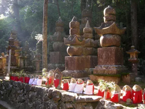 Buddhastatuen, die ein zinnoberrotes Lätzchen um den Hals tragen.