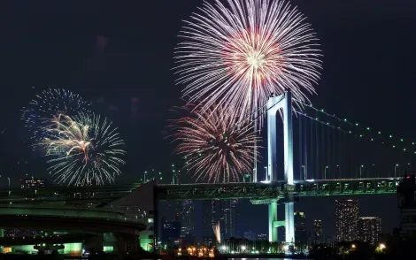 Le feu d'artifice du Tokyo Bay Fireworks derrière le Rainbow Bridge.