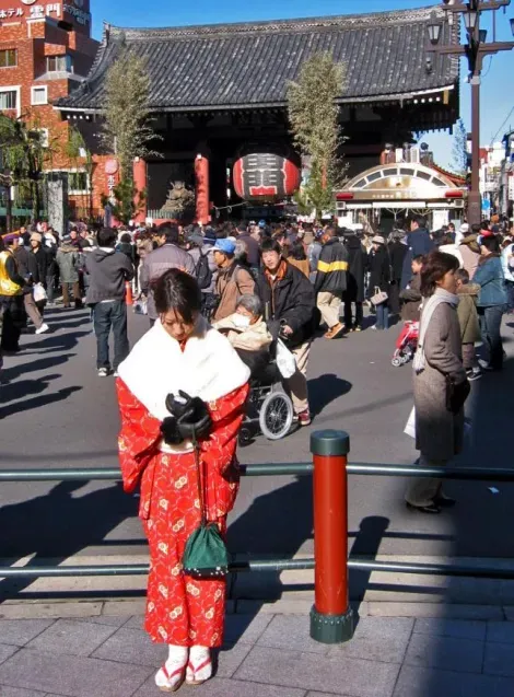 Una mujer vestida con kimono frente al templo Senso-ji en Asakusa, un primero de enero.
