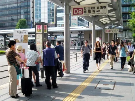 Un arrêt de bus de la gare de Kyoto. Les Japonais se mettent en rang en attendant l'arrivée du bus.