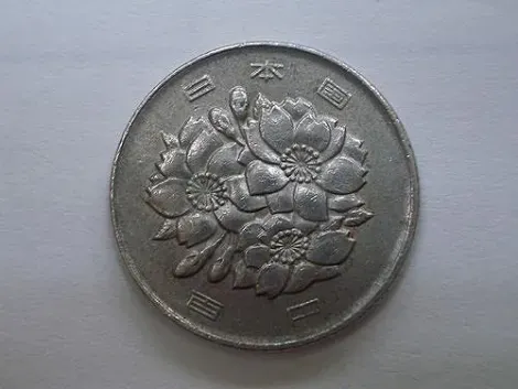 El la moneda de 100 yenes se pueden ver las flores de cerezo.