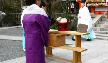 Una mujer que acaba de clavar sus agujas en el pedazo de tofu durante el Hari Kuyo.